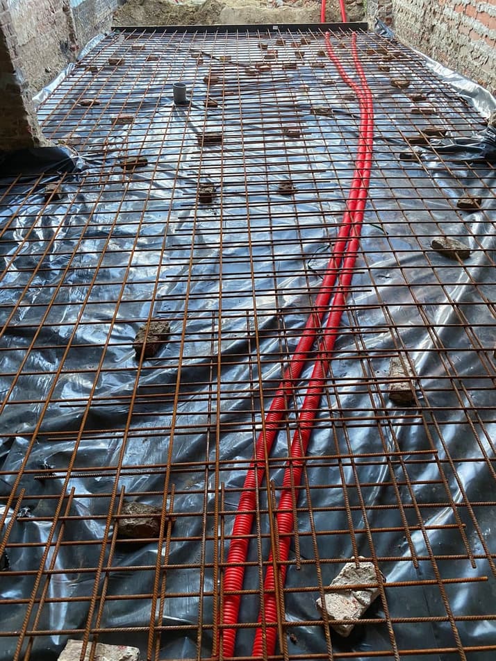 Wapeningsnet met leidingdoorvoeren, klaar voor het storten van de betonplaat