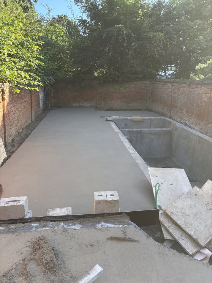Hellingschape rond een zwembad in aanbouw, binnen een omsloten tuin